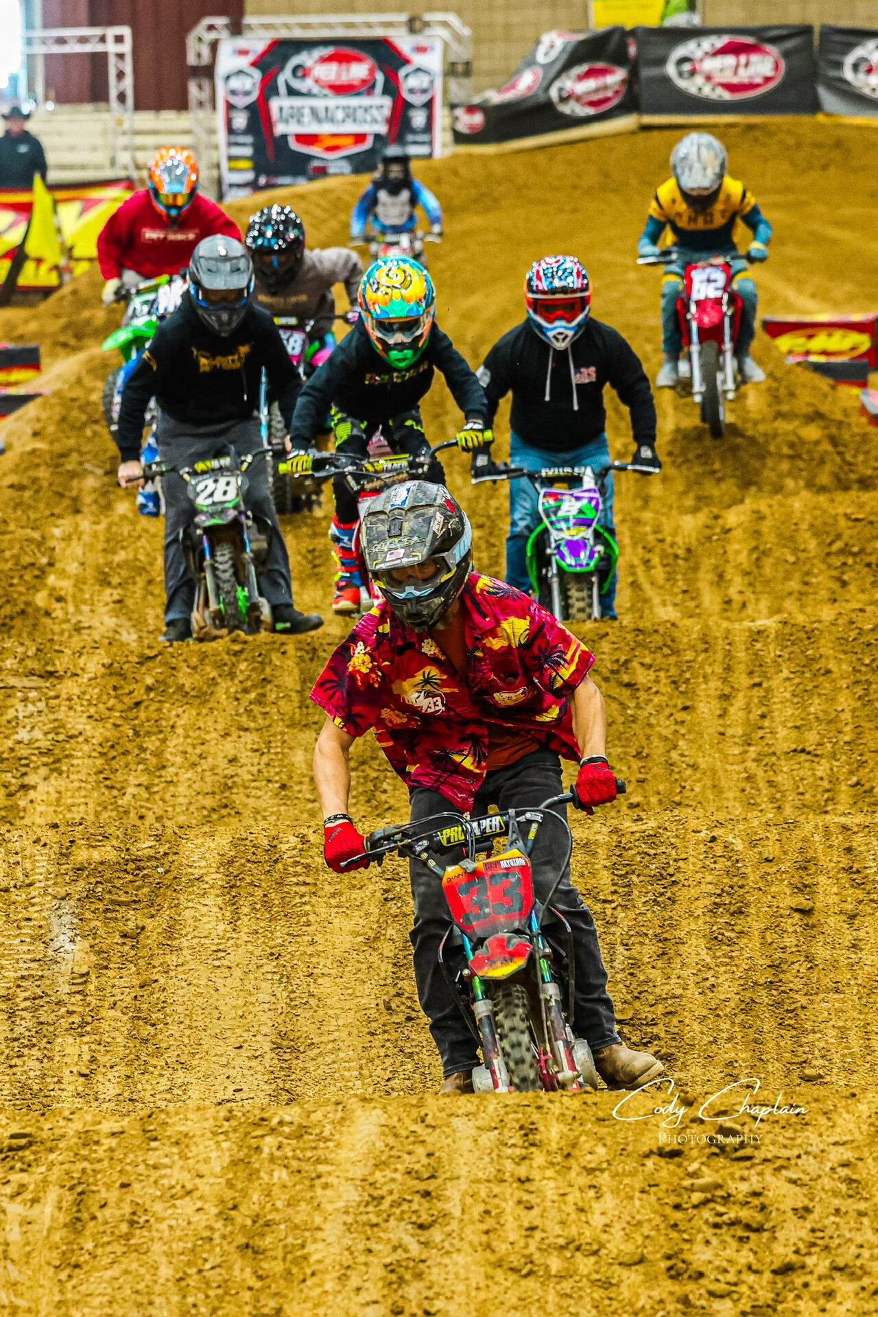 Pit bike racer railing a dirt berm
